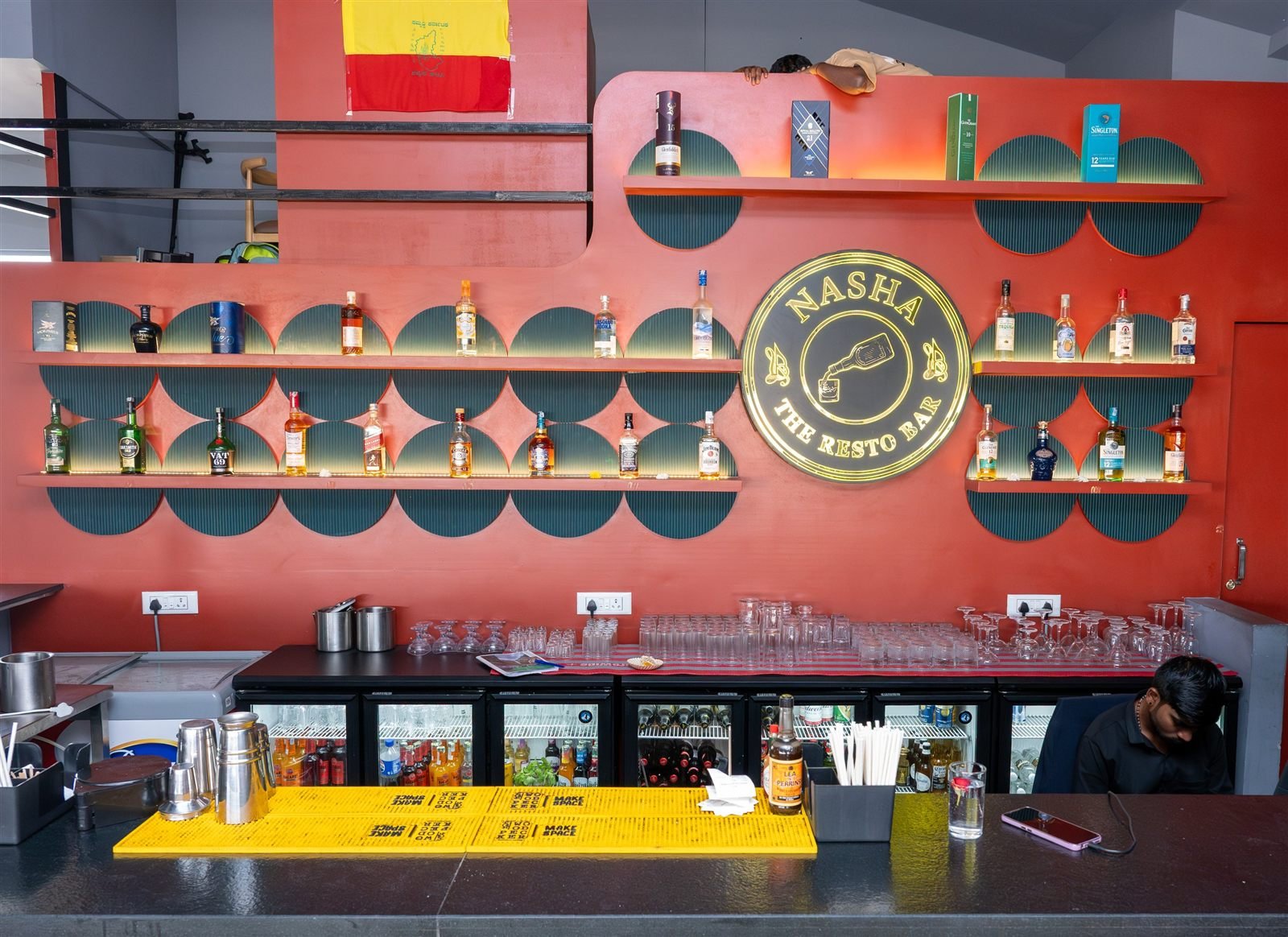 The Nasha bar with bottles on shelves against a red wall and the Nasha sign
