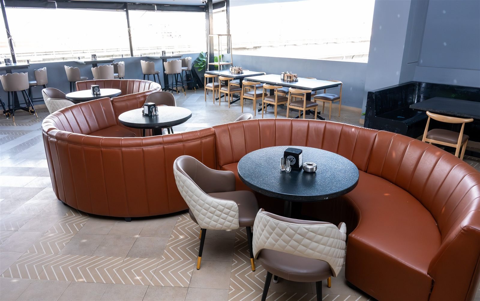 Booth and table seating beside the windows at Nasha