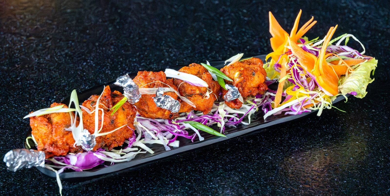 Grilled chicken pieces on a bed of shredded cabbage