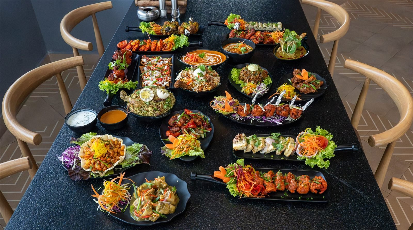 A table covered with Nasha starters, kababs, curries and biryani